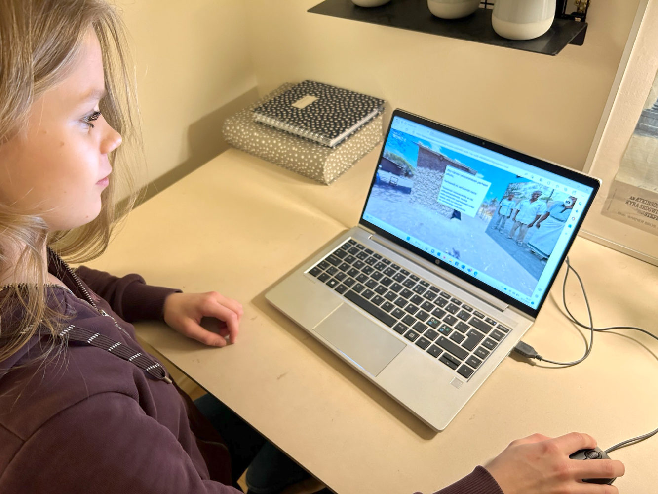 Flicka sitter framför dator och spelar VR-spelet.